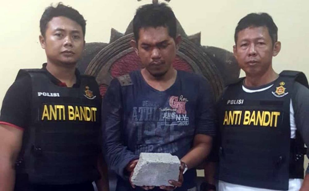 Doni (tengah) sang perampok yang lukai korbannya diamankan di Mapolsek Lakarsantri, Surabaya 