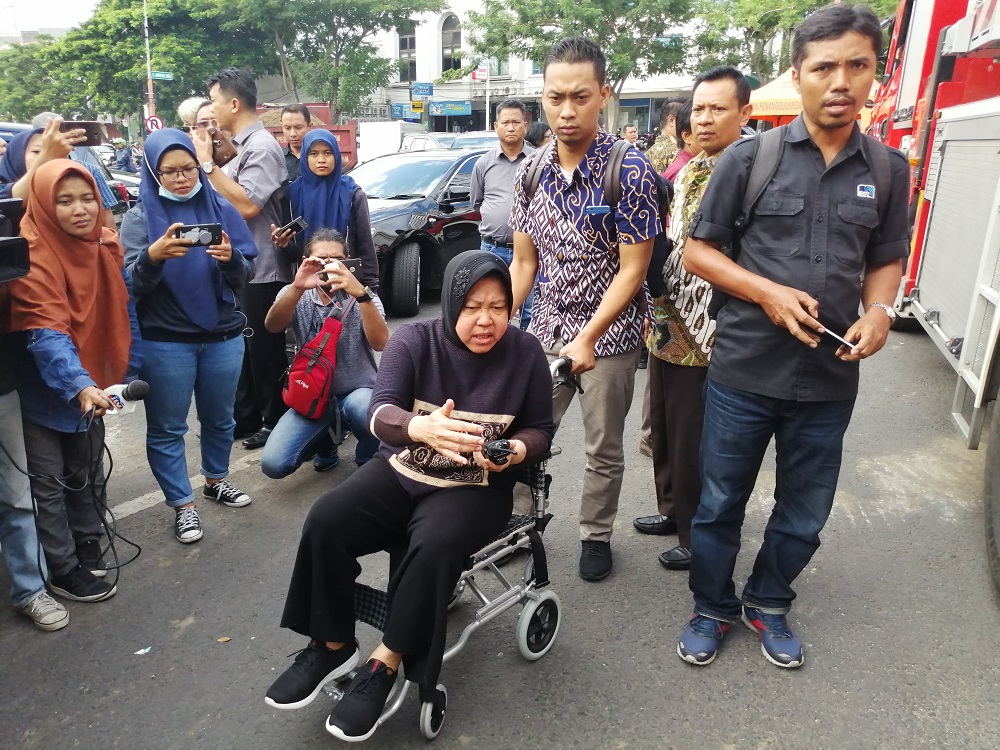 Wali Kota Surabaya Tri Rismaharini meninjau amblesnya Jalan Raya Gubeng dengan menggunakan kursi roda.