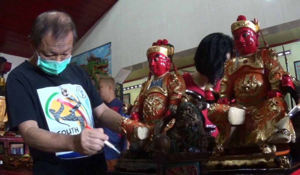 A Kiu, juru kunci Klenteng Poo An Kiong Blitar saat membersihkan patung dewa