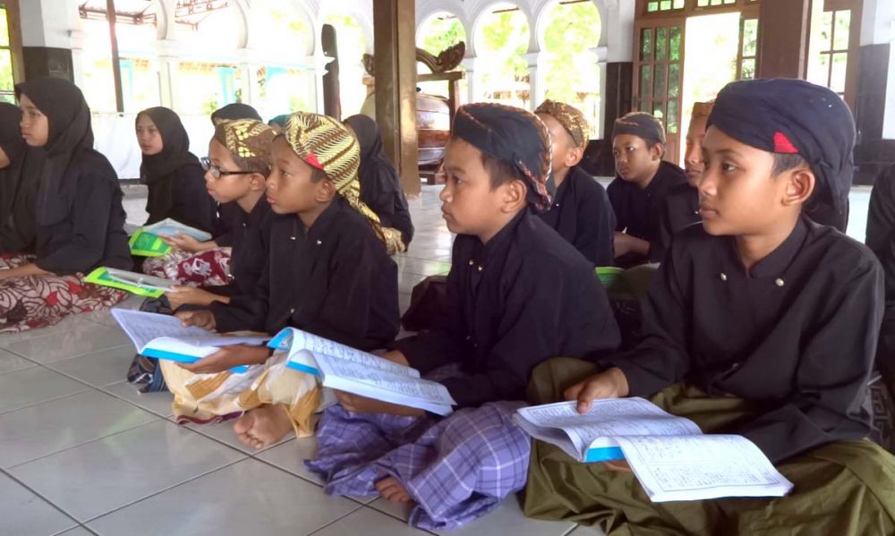 Para santri Madrasah Diniyah Zumrotus Salamah di Pondok Pesantren Tawangsari, Tulungagung menggunakan pakaian adat Jawa saat belajar