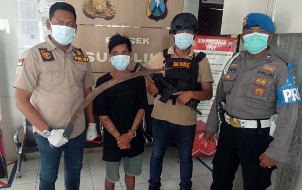 Kanit Reskrim Polsek Sukolilo Iptu Zainul Abidin (kiri) menunjukkan senjata tajam yang dibawa tersangka NAR (dua dari kiri) saat hendak tawuran