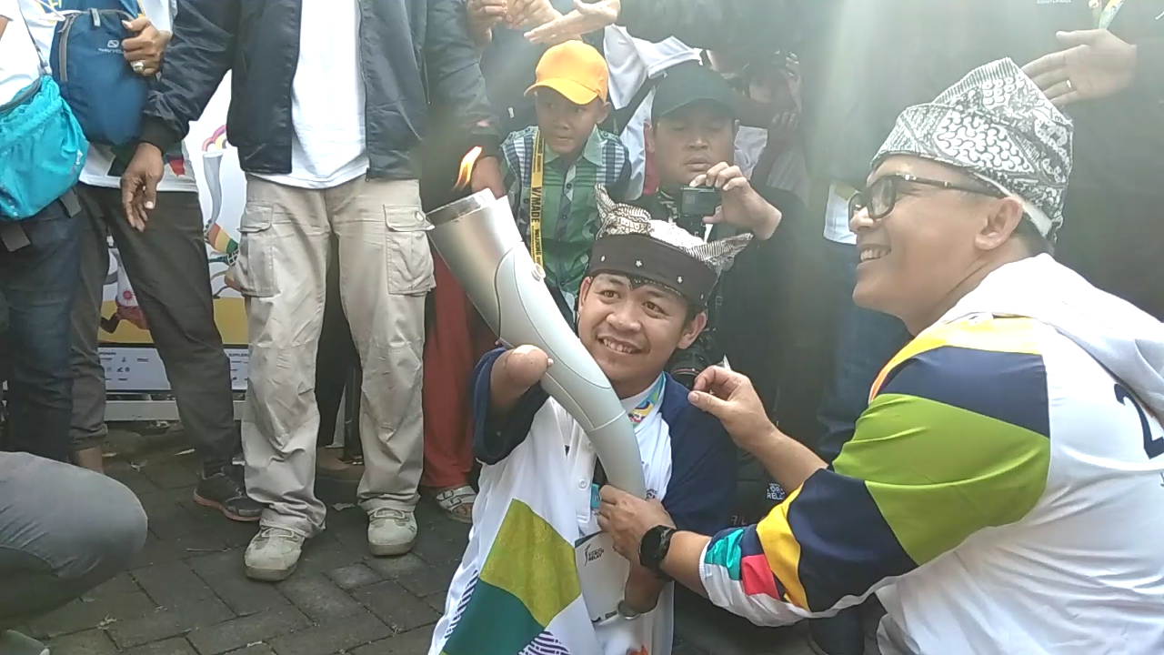 Ahmad Zulkarnain saat menerima obor Asian Games dari Bupati Anas