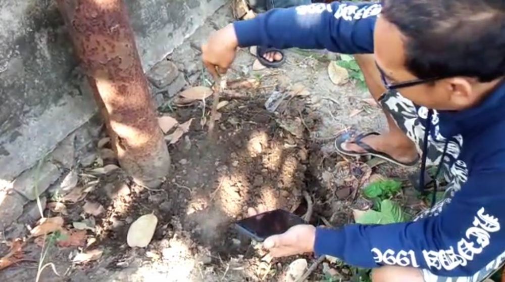 Warga mengorek tanah yang mengeluarkan bau dan kepulan asap