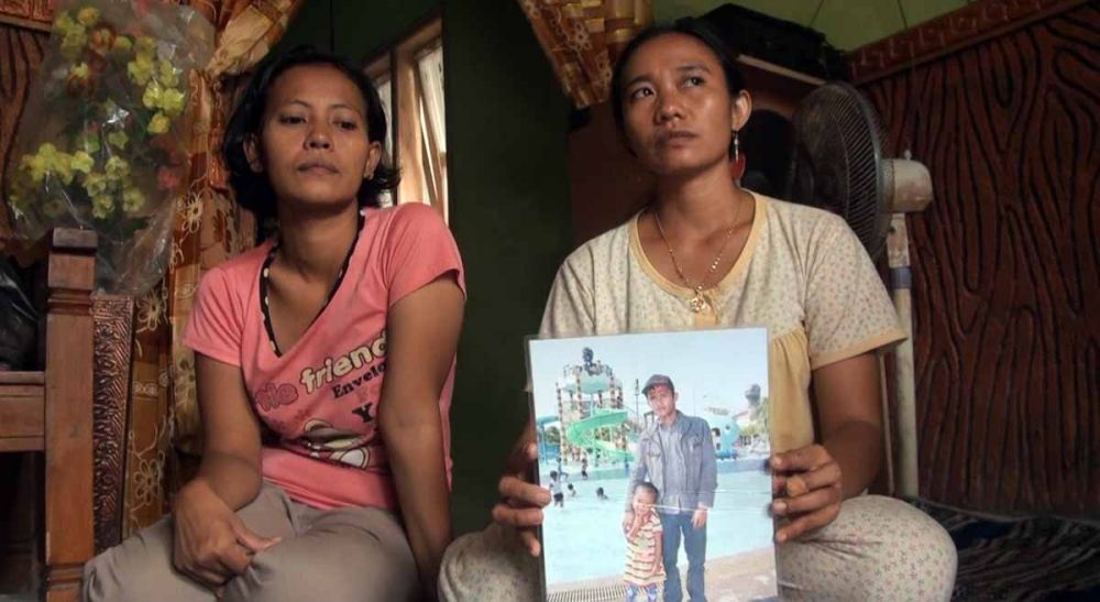 Evi Lailitus Saidah (kanan), menunjukkan foto semasa hidup Eko Yuswanto, sepupunya