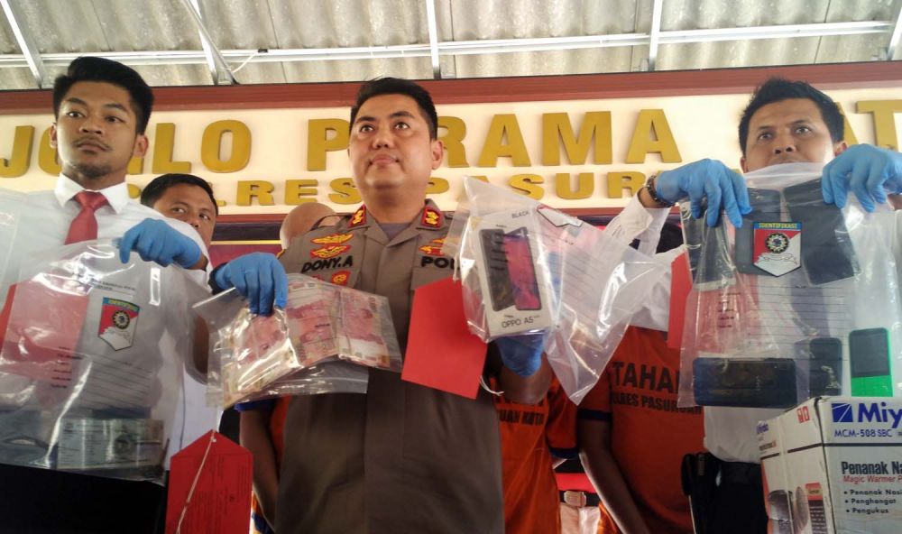 Kapolres Pasuruan Kota AKBP Dony Alexander membeberkan barang bukti kejahatan tiga pelaku sindikat penipuan