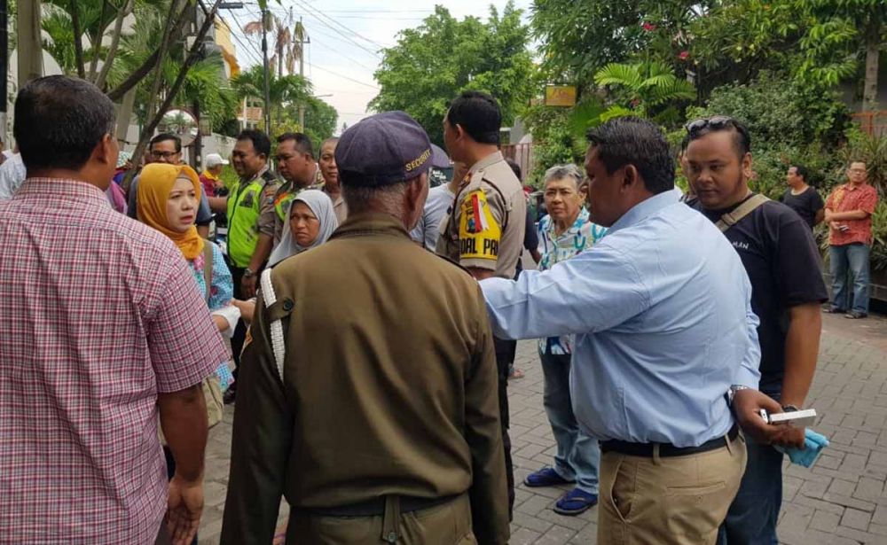 Polisi dan warga berada di lokasi ditemukannya mayat Soeharto di Jalan Pandugo Surabaya