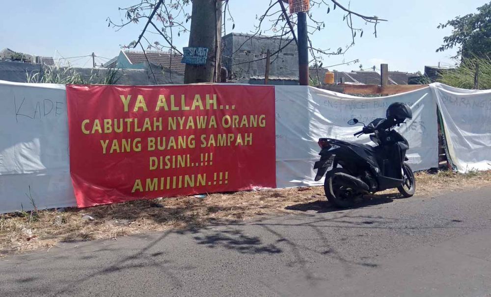 Spanduk peringatan untuk pembuang sampah terpasang di Dusun Tani Nelayan, Desa Pepe, Kecamatan Sedati, Kabupaten Sidoarjo (foto-foto: Achmad Supriyadi/jatimnow.com)