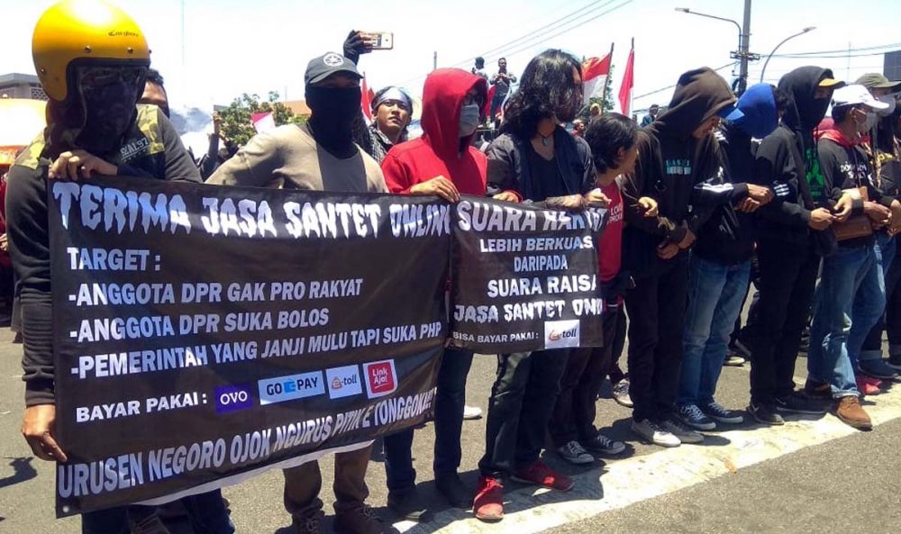 Spanduk horor dibentangkan beberapa pria bermasker dalam demo 26 September di depan Gedung DPRD Jatim, Surabaya (foto-foto: Farizal Tito/jatimnow.com)