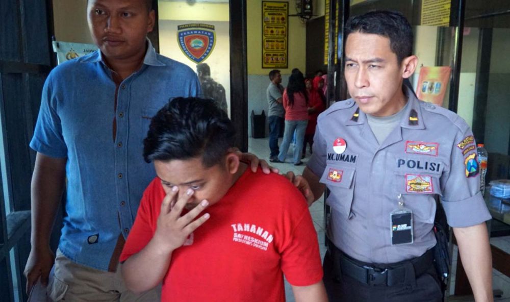 Susilo (tengah) suami yang tega jual istrinya untuk layanan seks threesome diamankan di Mapolrestabes Surabaya