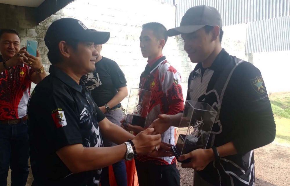 Juara 1 Standart Non Sertifikasi Division Awalludin Ilham atau Hami (kanan) menerima piala dari Kasie Olahraga Rekreasi Dispora Surabaya, Wahyu Widayat