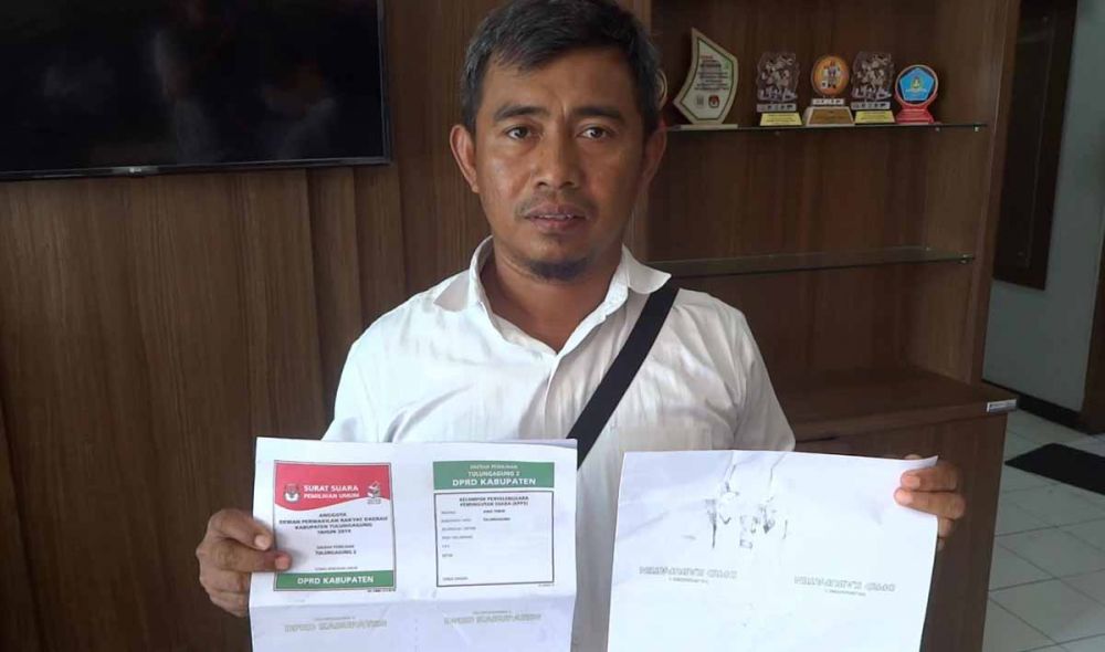 Petugas KPU Tulungagung menunjukkan temuan saat penyortiran dan pelipatan surat suara pileg 
