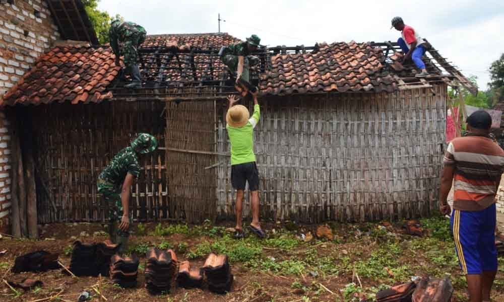 Prajurit TNI bekerja merenovasi rumah warga 