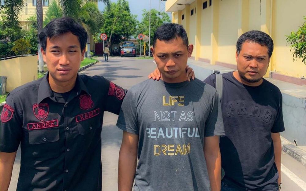 Kanit Resmob Satreskrim Polres Mojokerto Ipda Prima Andre Rinaldo Azhar (kiri) menggiring TNI gadungan (tengah)