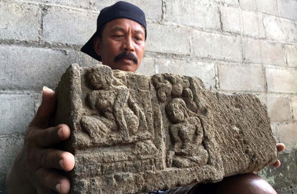 Warga menunjukkan potongan relief bergambar wanita yang ditemukan di Kelurahan Gedog, Kota Blitar