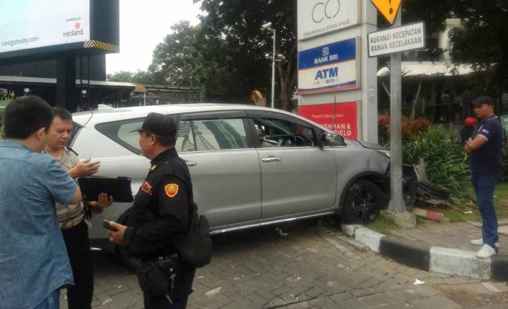 Mobil Innova menabrak neon boks dan tiang rambu lalu lintas di Jalan Mayjen Yono Suwono, Surabaya
