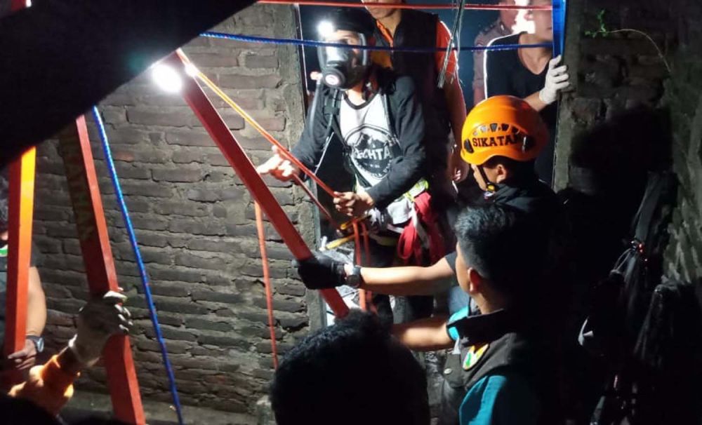 Petugas mengevakuasi jasda korban dari dalam sumur