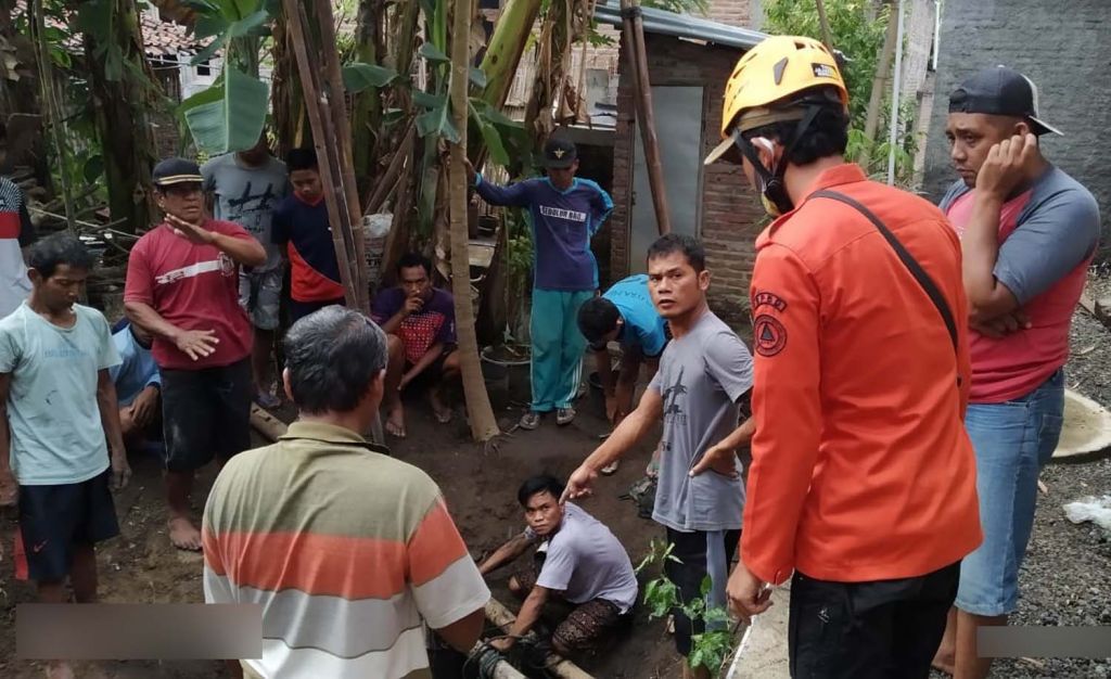 Tim BPBD Ponorogo bersama warga mengevakuasi seekor sapi yang terporosok ke dalam septic tank