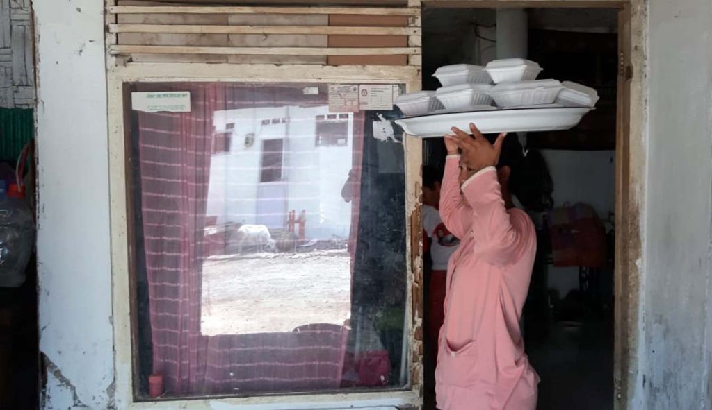 Seorang warga membawa jenang untuk dibagikan ke tetangga dalam tradisi sedekah jenang sapar di Probolinggo