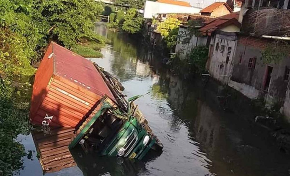 Truk trailer bermuatan triplek nyemplung ke sungai di Ketegan, Taman, Sidoarjo (foto: Istimewa)