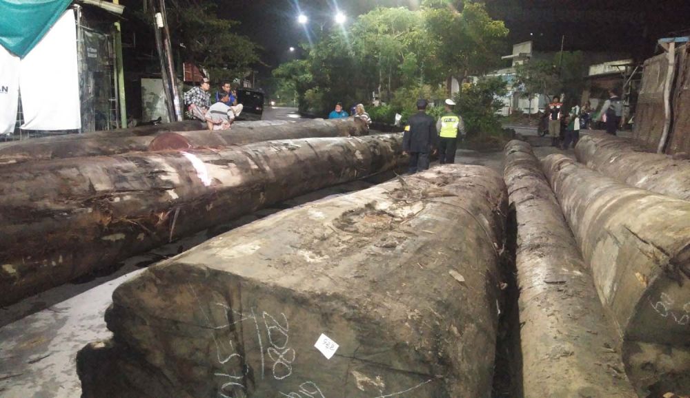 Sejumlah kayu gelondongan yang diangkut truk trailer tumpah dan sempat menutup jalan di Surabaya (Foto-foto: Jajeli Rois/jatimnow.com)