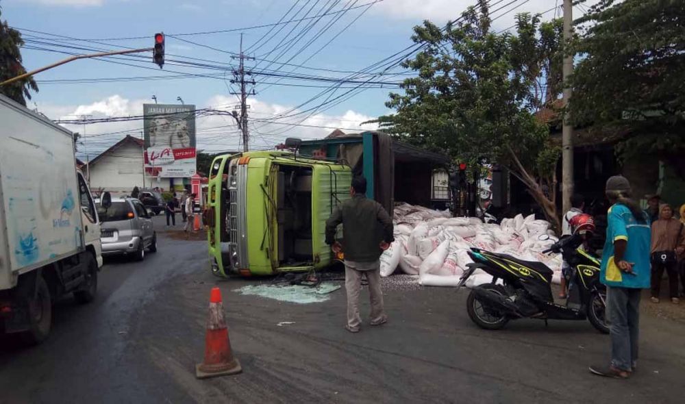 Pupuk yang diangkut truk gandeng tumpah dan sempat menutup badan jalan di Banyuwangi