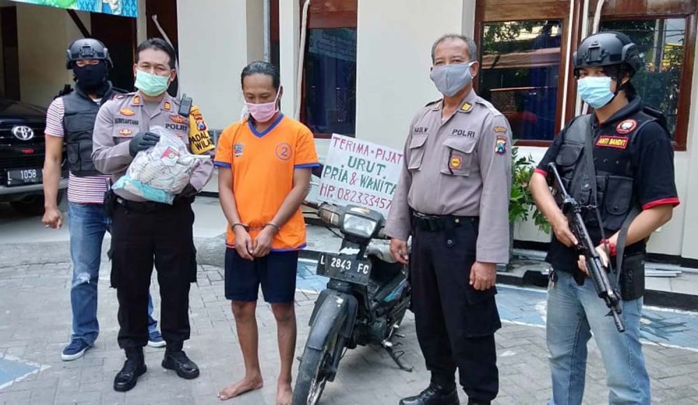 Tukang pijat keliling cabul (tangan diborgol) diamankan di Mapolsek Sukolilo, Surabaya