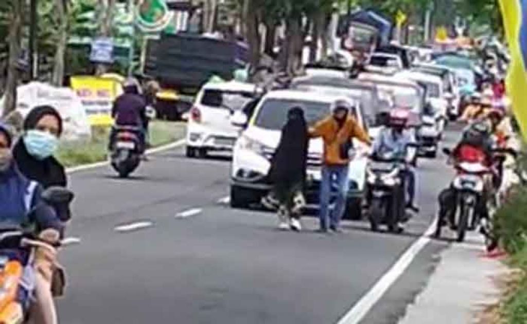 Tangkapan layar video wanita berjalan di tengah menyebabkan kemacetan