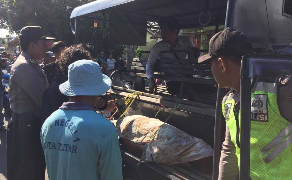 Polisi dibantu warga mengevakuasi jasad korban dari bantaran kali di Kota Blitar