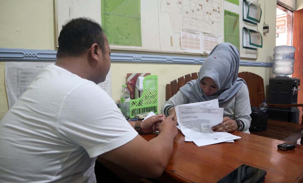 Sugeng alias Berbie (berjilbab) saat menjalani pemeriksaan di Mapolsek Ponorogo Kota