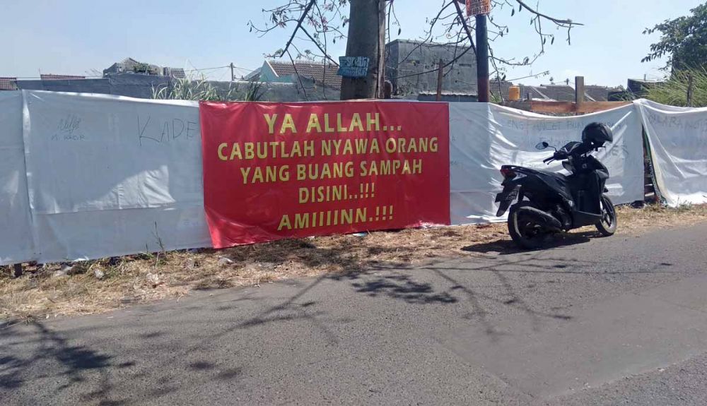 Spanduk peringatan untuk pembuang sampah terpasang di Dusun Tani Nelayan, Desa Pepe, Kecamatan Sedati, Kabupaten Sidoarjo (foto: Achmad Supriyadi/jatimnow.com)