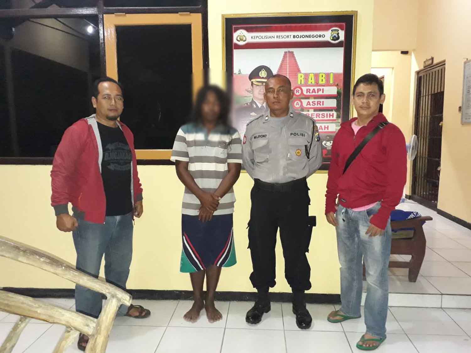 Tersangka (baju garis-garis) didampingi petugas,