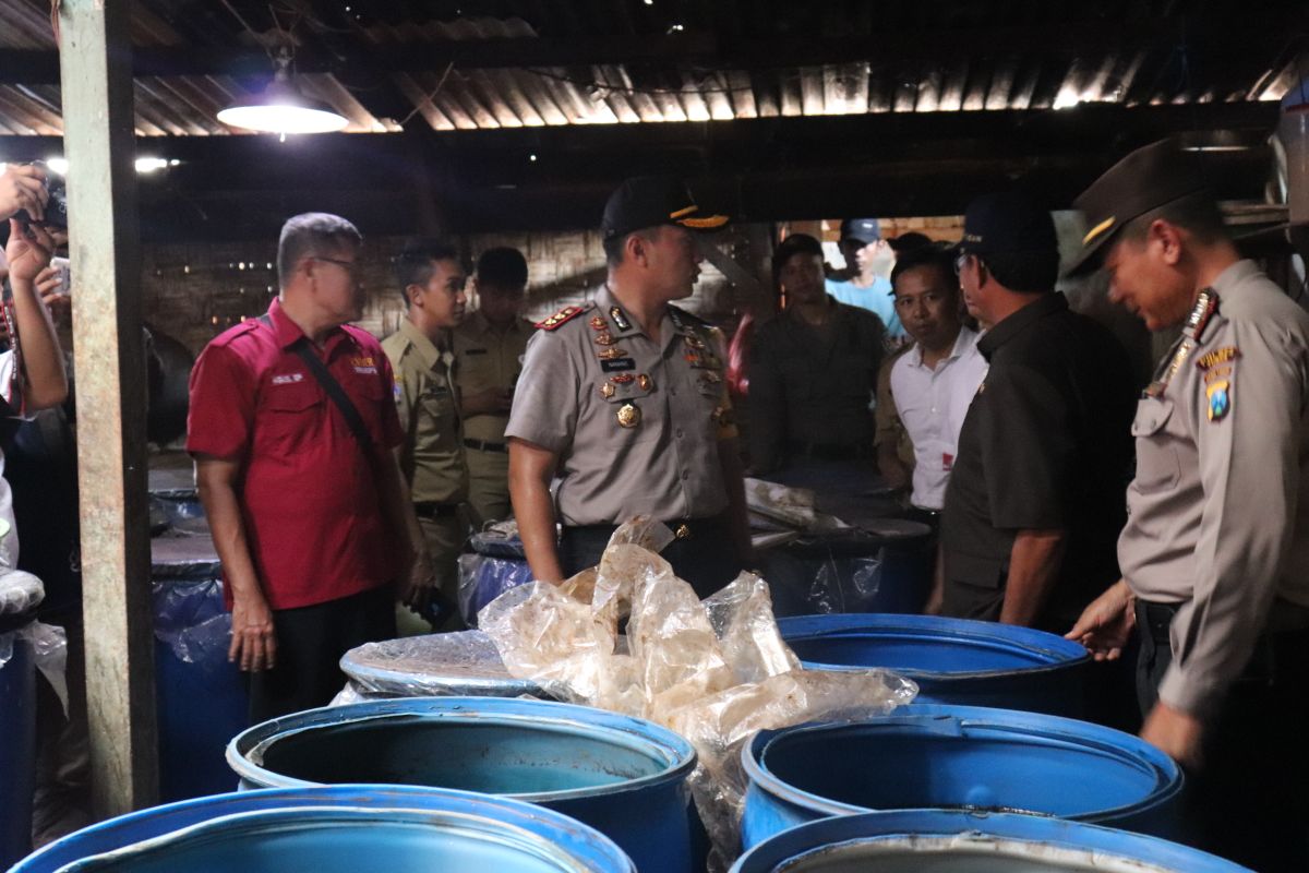 Petugas melihat tempat drum-drum tempat penampungan arak.