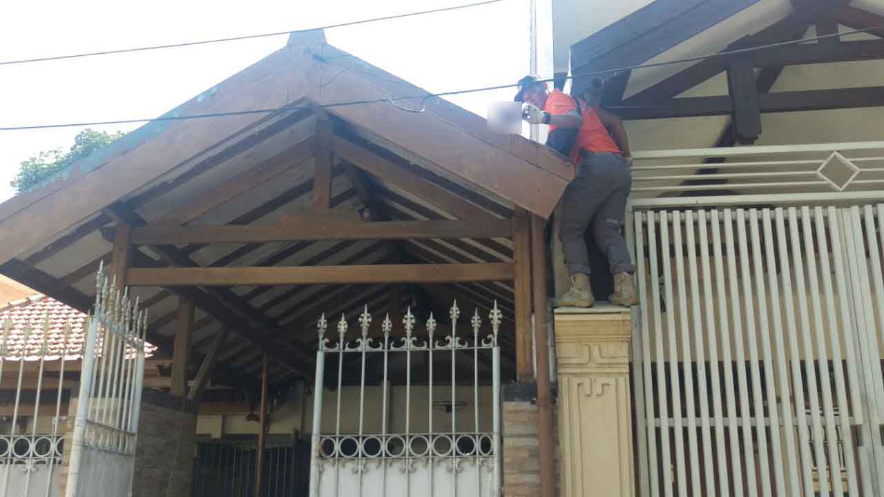 Petugas mengambil serpihan tubuh korban ledakan bom di atap rumah.