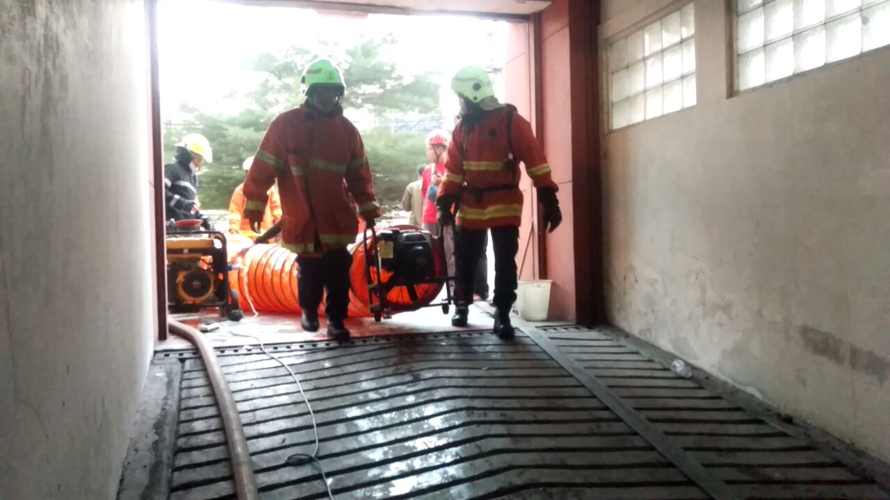 Petugas menggunakan blower untuk menyedot asap