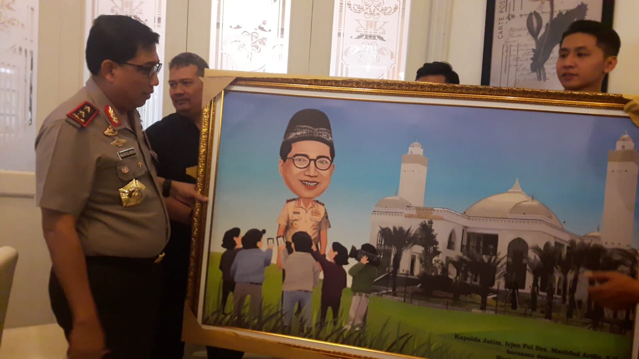 Kapolda Jawa Timur Irjen Pol Machfud Arifin saat diberi hadiah karikatur oleh pokja Polda Jatim.