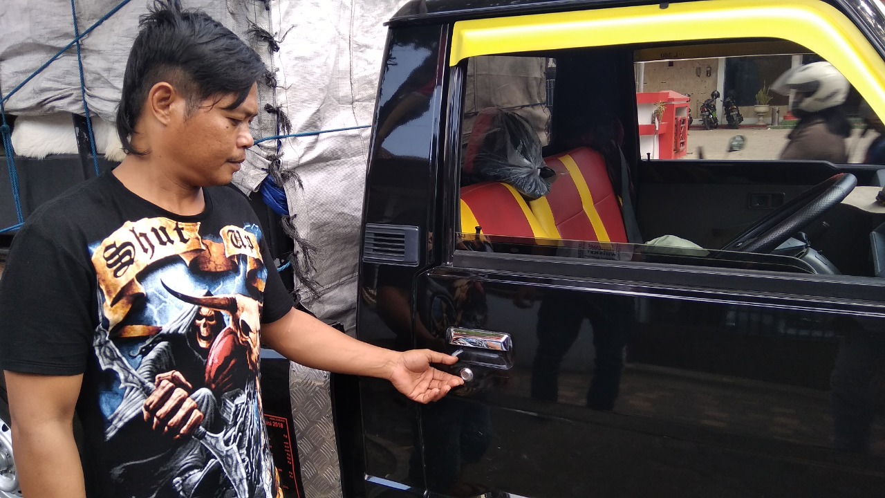 Korban menunjukkan pintu mobil yang dirusak pelaku