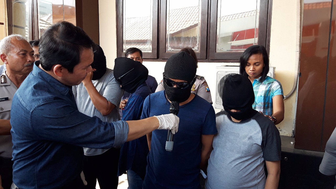 Polisi memamerkan barang bukti pesta seks tukar pasangan/Foto: Arry Saputra/jatimnow.com
