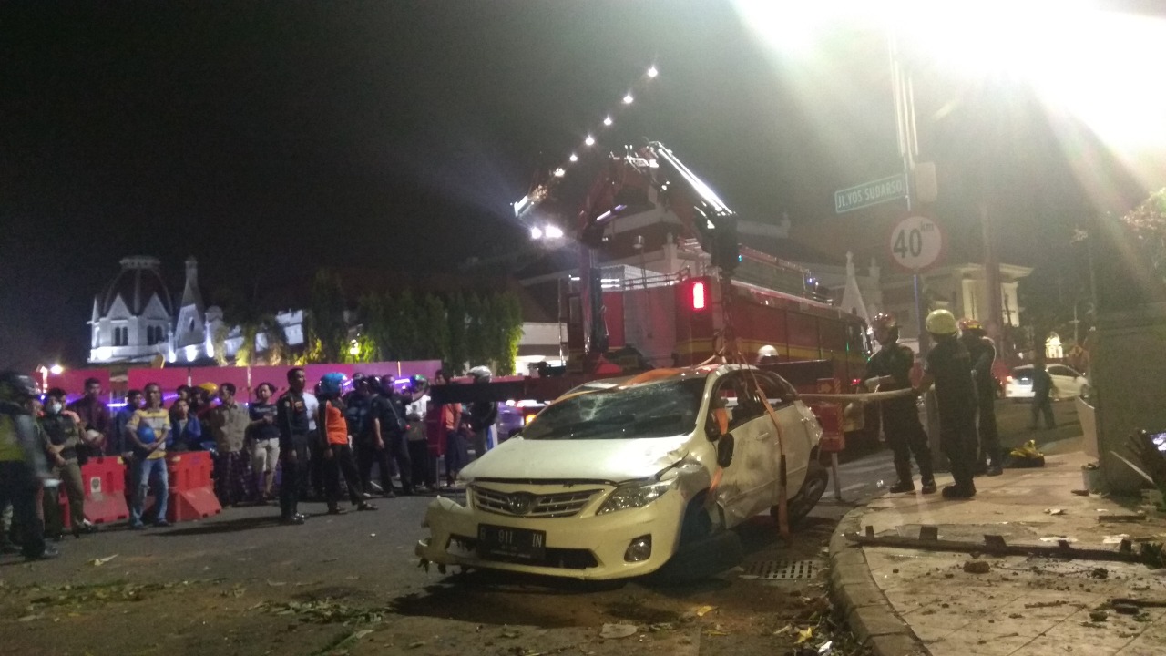 Petugas mengevakuasi mobil yang menabrak taman di Perempatan Jalan Pemuda