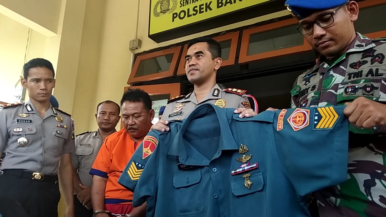 Petugas menunjukkan tersangka dan bukti seragam TNI AL yang digunakan tersangka