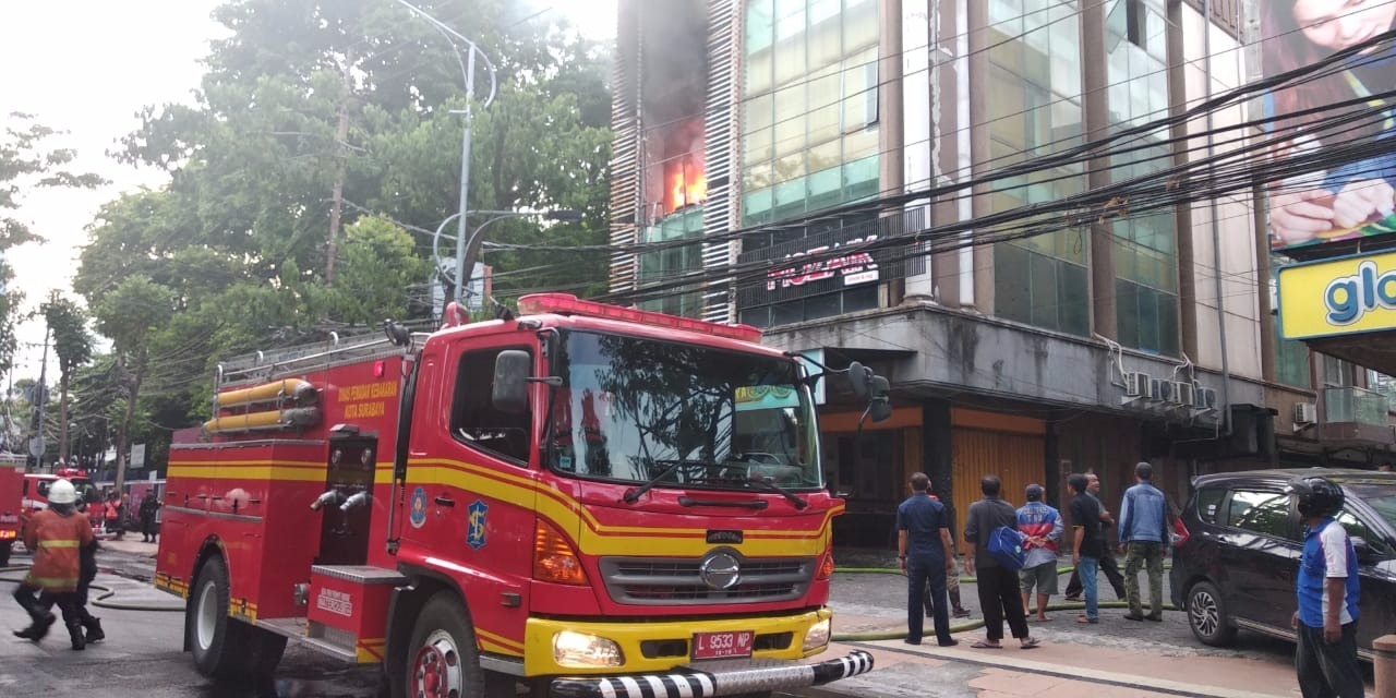 Petugas pemadam kebakaran memadamkan api di ruko yang terbakar