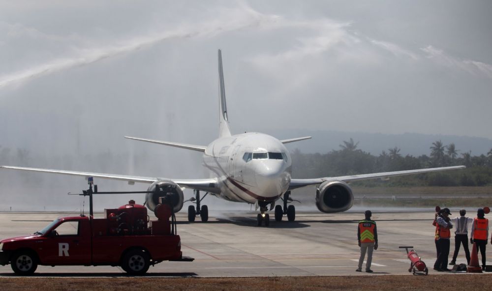 Pesawat Xpress Air rute Banjarmasin terbang perdana ke Bandara Banyuwangi, Sabtu (10/8/2019). Kedatangan pesawat jenis Boeing itu disambut dengan siraman air./ foto Budi Sugiharto