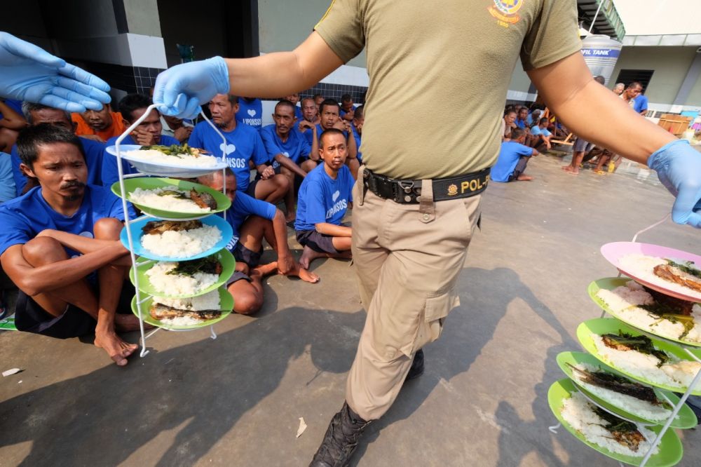 Anggota Satpol PP membantu makanan di Liponsos Keputih/ foto-foto Budi Sugiharto/ jatimnow.com.