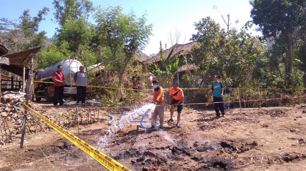 Petugas BPBD padamkan semburan api dari tanah ladang di Ponorogo