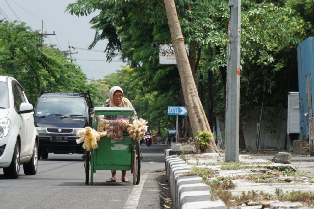 Mbah Hawati saat mendorong gerobaknya di Kawasan Ngagel/Foto: Fajar Mujianto-jatimnow.com
