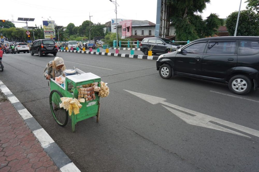Mbah Hawati mendorong gerobaknya di jembatan Ngagel pada Rabu (13/11/2019) (Foto: Fajar Mujianto-jatimnow.com)