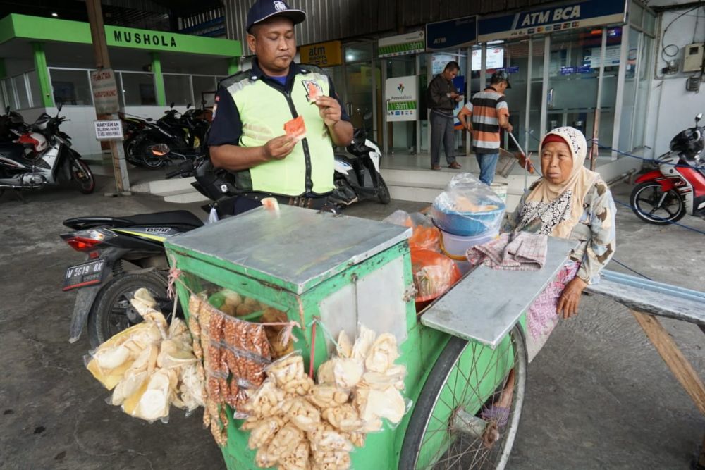 Mbah Hawati melayani pembeli dagangannya/ foto: Fajar Mujianto-jatimnow.com