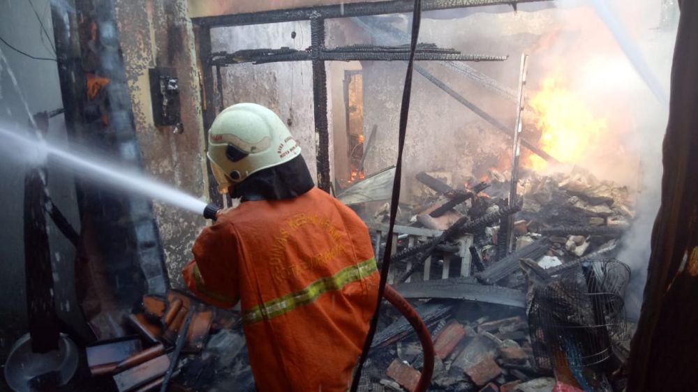 Petugas memadamkan api yang membakar rumah di Manyar Sabrangan Surabaya