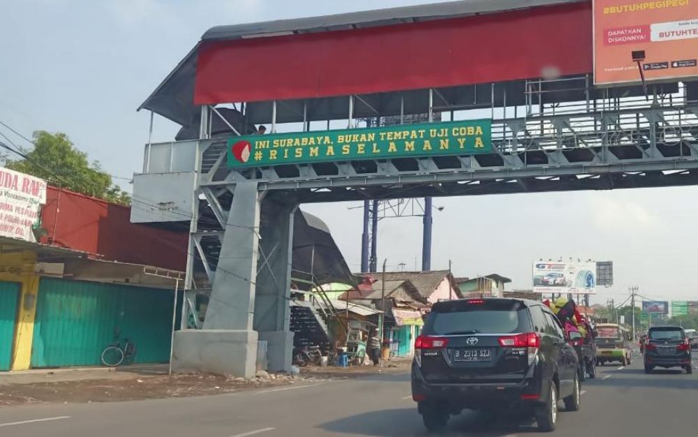 Spanduk dukungan pada Risma yang terpasang di JPO Wonokromo