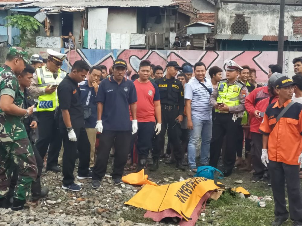 Petugas mengevakuasi korban tewas setelah tertabrak kereta