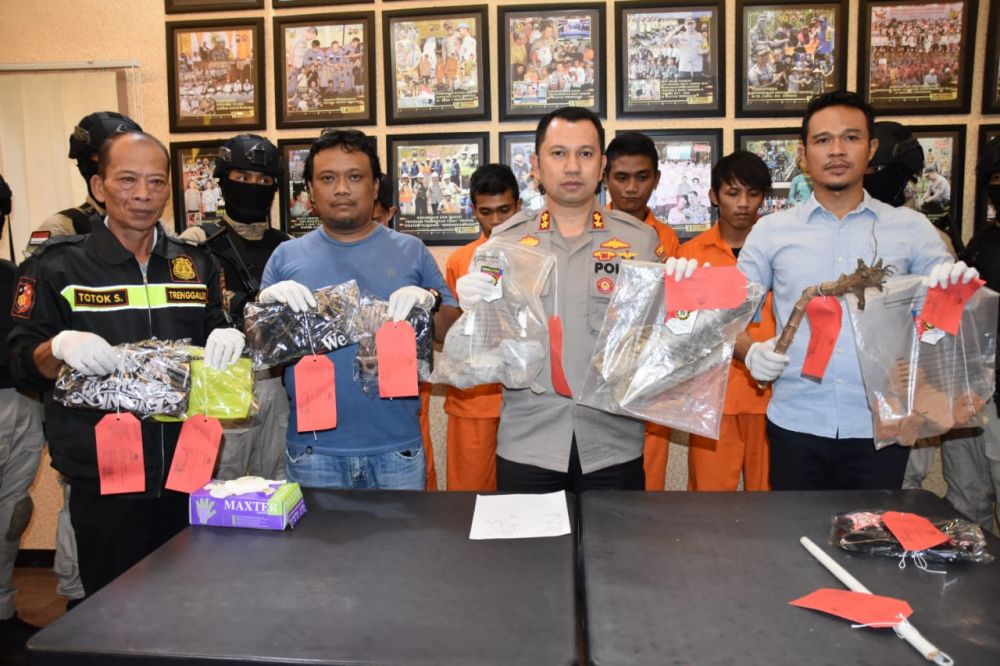 Kapolres Trenggalek AKBP Jean Calvijn Simanjuntak menunjukkan barang bukti kasus pengeroyokan dan perusakan rumah